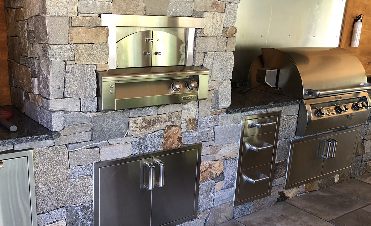 Outdoor kitchen design with natural stone by Nest Outdoors of Bedford New Hampshire