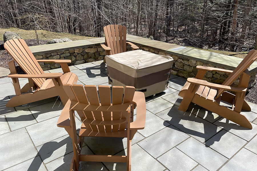Cozy bluestone patio with stone sitting walls designed and installed by Nest Outdoors