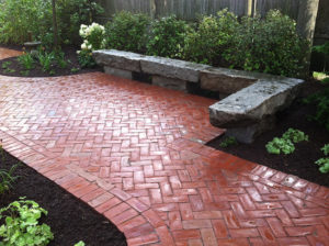 Landscape designer in Bedford NH Nest outdoors installed this brick patio with rustic granite benches